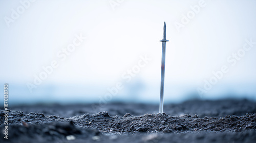 Sword of Solitude Emerges From the Desolate Earth Beneath a Clouded Sky, Evoking a Sense of Ancient Mystery and Forgotten Tales