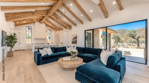 Open concept luxury living area features vaulted wood beam ceilings and outdoor patio access