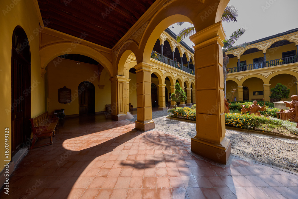 Naklejka premium Silence and sunlight in the heart of Lima. The Convento de Santo Domingo offers a peaceful escape from the bustling city streets, where centuries of history are preserved in every carved wooden 