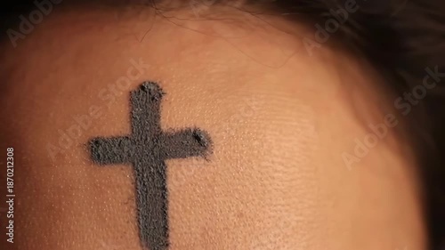 Close up video of a woman forehead with an ash cross on ash wednesday, a christian holy day of prayer, fasting, and repentance.
