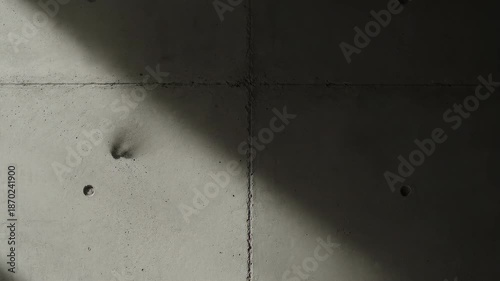 Smoke flowing from a hole in a concrete wall, illuminated by sunlight. Captures movement, texture, and interplay of light and shadow.