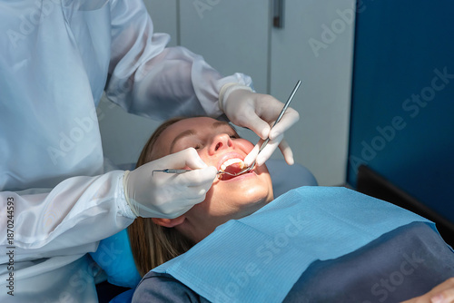 Cuadro en lienzo Dentist performing routine dental checkup and oral examination of a patient using mirror and probe