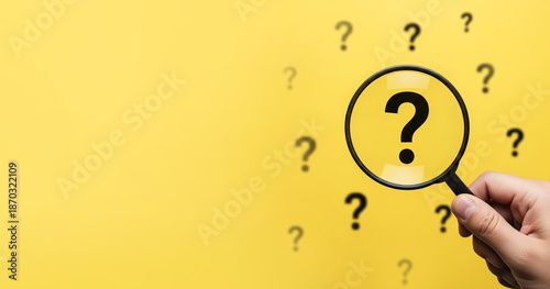 Finding Answers Concept with Hand and Magnifying Glass Over Question Mark, Yellow solid background.