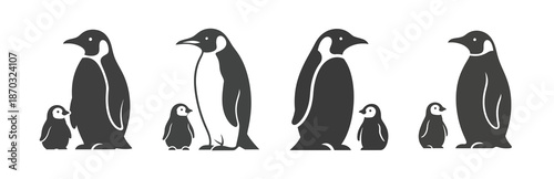 Silhouettes of adult emperor penguins and their chicks standing side by side in a row