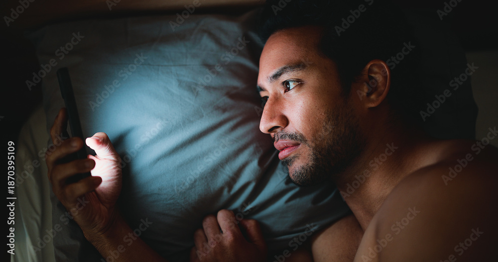 Obraz premium Night, man and reading in bed with phone for text message reply, social media and check dating site. Late, person and scroll with tech in apartment for online conversation, internet and mobile app.