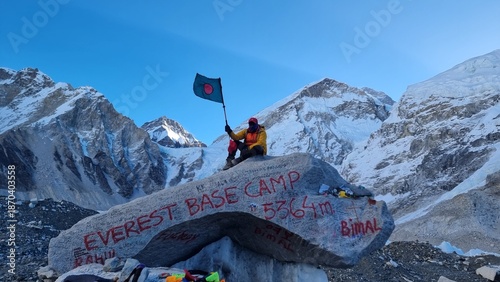 Obraz na płótnie Adventurer celebrates achievement at Everest Base Camp, proudly displaying a nat