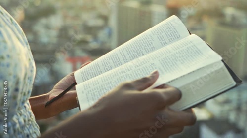 young black Woman afro american Reading Bible at Sunset Outdoors