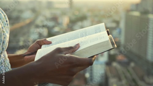 young black Woman afro american Reading Bible at Sunset Outdoors