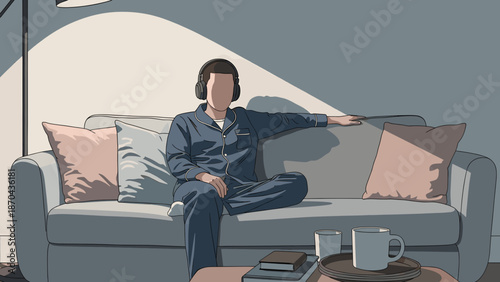 A person in pajamas wearing headphones, sitting comfortably on a couch with a cup of coffee and books nearby