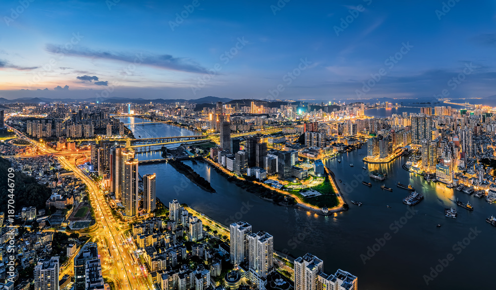 Fototapeta premium Vibrant modern city skyline with illuminated building and river at night in Zhuhai, China.