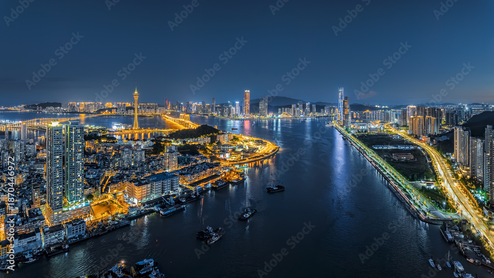 Obraz premium Aerial view of the vibrant city skyline at night in Macau.