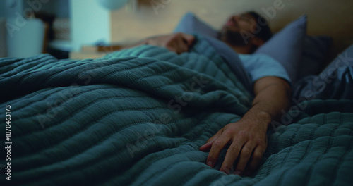 Photos Sleeping, tired and man in bed at night for resting, dreaming and exhausted for nap in home