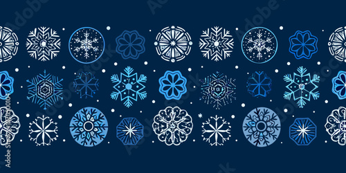 Seamless pattern of delicate blue and white snowflakes on a dark background
