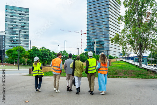 Fotografia Diverse team of engineers and architects walking towards urban development site