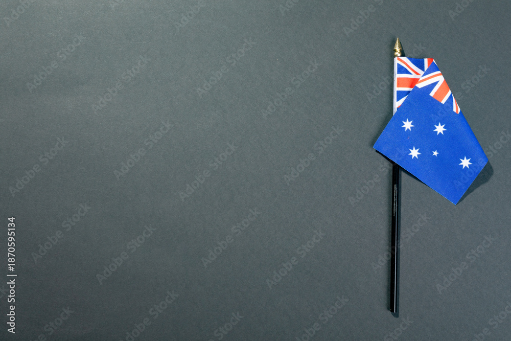 Fototapeta premium Stars and union jack on australia flag stick by copy space over black table