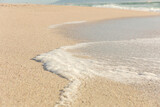 High angle view of white sea wave foam on shore at sunny beach