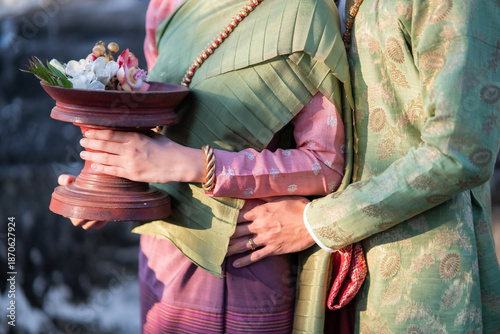 Couple wearing traditional Lanna attire holding floral offering in northern Thailand