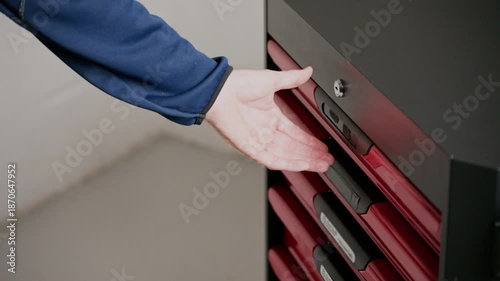 Hand reaching for tool cabinet drawer handle