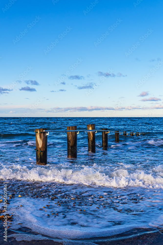 Fototapeta premium Wellen und Buhne am Strand der Ostsee in Heiligendamm