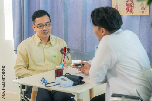 A male doctor sat at a table in a hospital, discussing models of the male urinary system, such as benign prostatic hyperplasia (BPH), prostatitis, and cystitis.