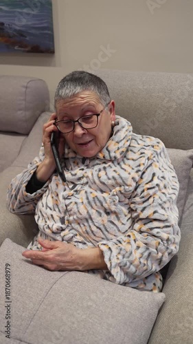 Cheerful elderly woman talking on a cordless phone