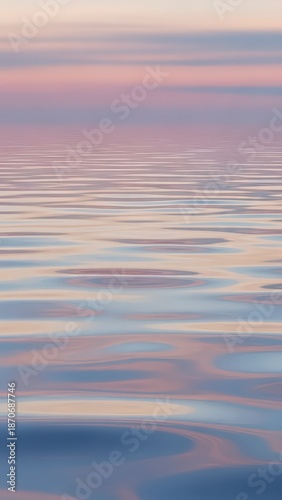 A beautiful sunset reflects over the calm sea horizon where the sun meets the blue ocean waves under a summer sky of abstract orange clouds and nature’s light
