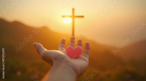 Wide symbolic scene of a hand offering a heart with a blurred cross behind, warm sunrise glow and bokeh for faith, hope and love concept