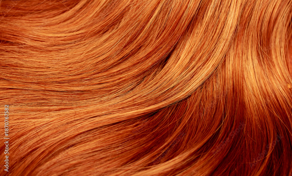 Fototapeta premium Red hair close-up as a background. Women's long orange hair. Beautifully styled wavy shiny curls. Hair coloring bright shades. Hairdressing procedures, extension.