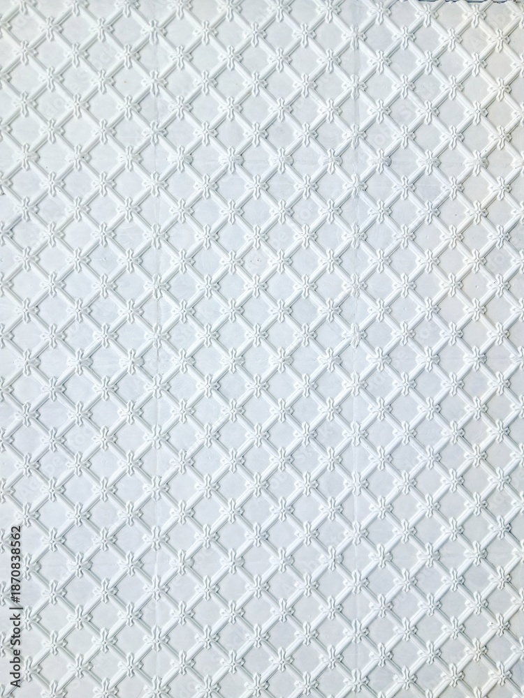 Naklejka premium Elegant white ornamental wall panel with embossed floral lattice pattern.
