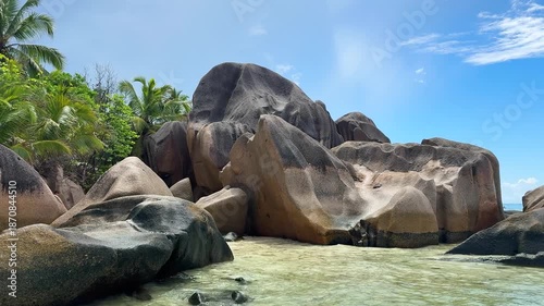 Explore rocky beach with clear water and green cliffs during sunny day