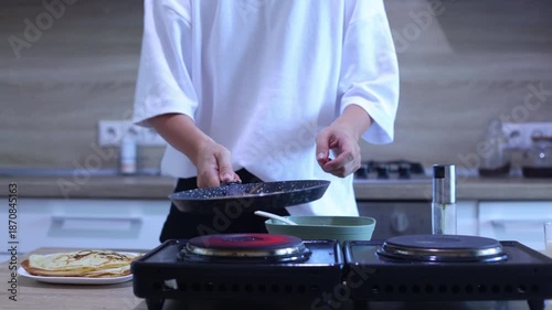 Watch a smooth, confident crepe flip using only the pan no spatula needed. The cook then gently slides the golden crepe onto a plate with others, perfect for breakfast or dessert lovers.