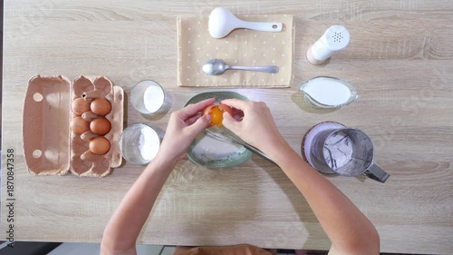 Top-down view of hands cracking an egg into a bowl of flour mixture, then whisking it smooth. Perfect for baking tutorials clean, simple, and focused on foundational techniques.