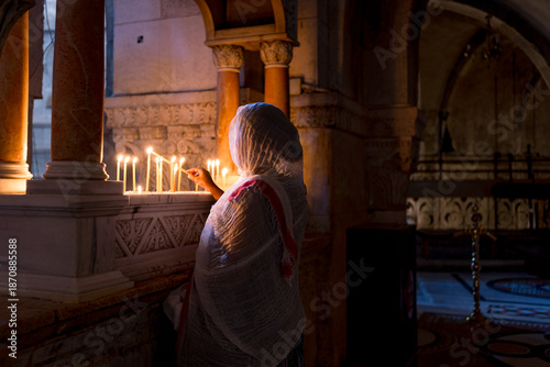 A woman lights a candle inside Church of the Holy Sepulchre in Jerusalem, symbol of hope