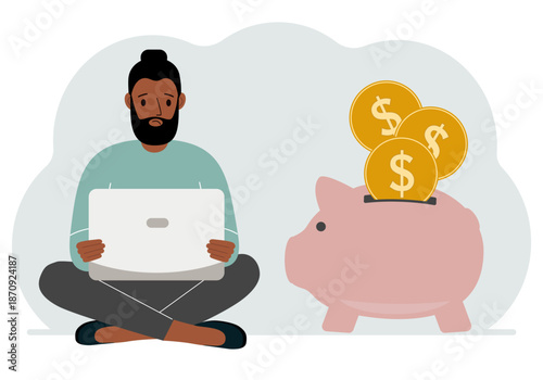 A man sits cross-legged with a laptop next to a pig piggy bank. Earning money, saving, saving money.
