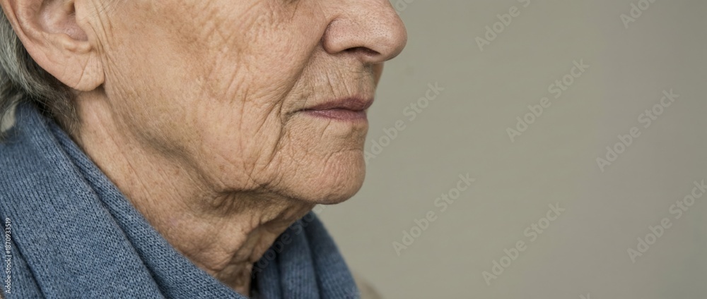 Fototapeta premium Senior woman in profile closeup, her face showing the natural process of aging with wrinkles and gray hair, representing wisdom and the progression of time
