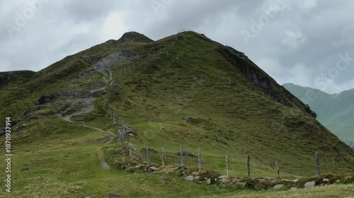 Winding Mountain Path Leading Up a Green Slope Under Cloudy Sky in Koenigsleiten, Austria