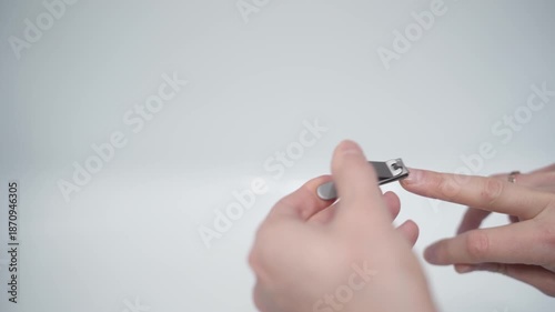 Cutting nails on a man's hand with nail tongs on a white background. Care for hands.