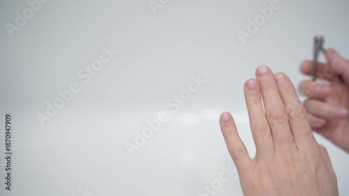 Cutting nails on a man's hand with nail tongs on a white background. Care for hands.