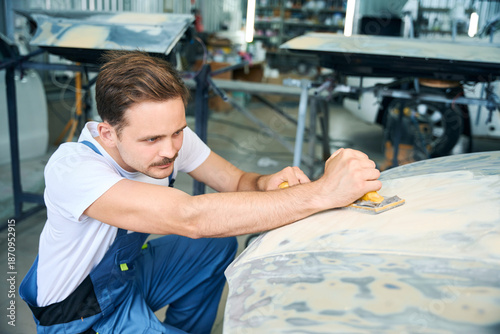 Fotografi Auto mechanic worker polishing car at automobile service station shop by power b