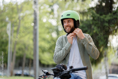 Wallpaper Mural Man prepares for a bike ride while putting on a helmet in a park during daytime Torontodigital.ca