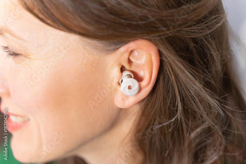 Beautiful woman using  ear plugs for noise protection