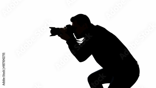 Silhouette of a photographer holding a camera and taking a picture.