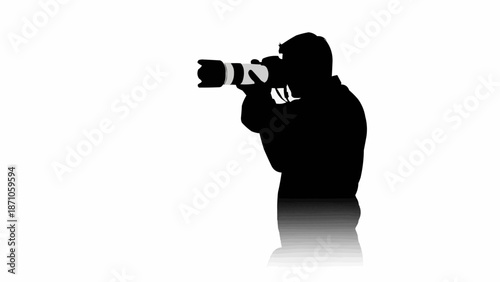 Silhouette of a photographer holding a professional camera and lens.