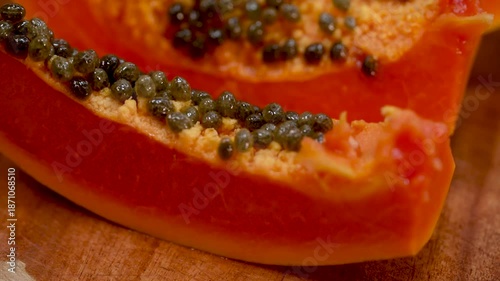 Close-Up Macro of Ripe Red Papaya Slices and Black Seeds.