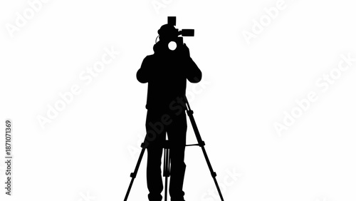 Silhouette of a videographer operating a professional camera on a tripod.