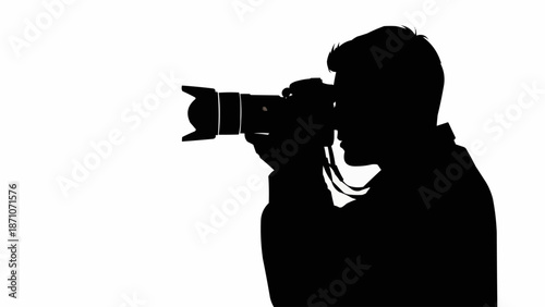 Silhouette of a photographer holding a professional camera and taking a picture.