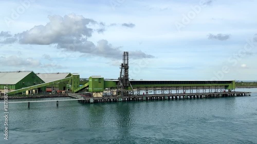 Port facility located by the water with loading equipment in action during daytime
