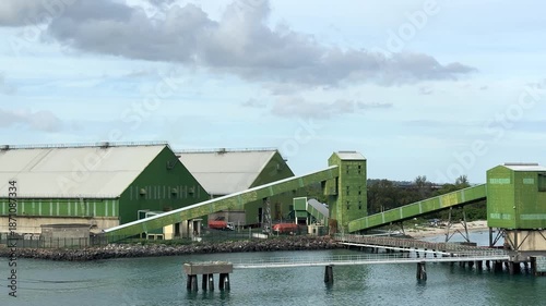 Port facility located by the water with loading equipment in action during daytime