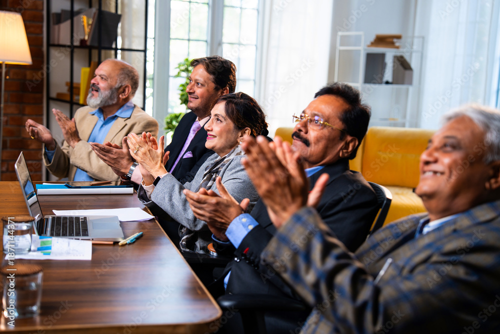Obraz premium Senior Indian executives applauding successful business presentation in modern corporate office