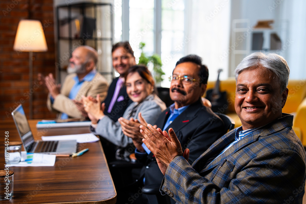 Obraz premium Senior Indian executives applauding successful business presentation in modern corporate office